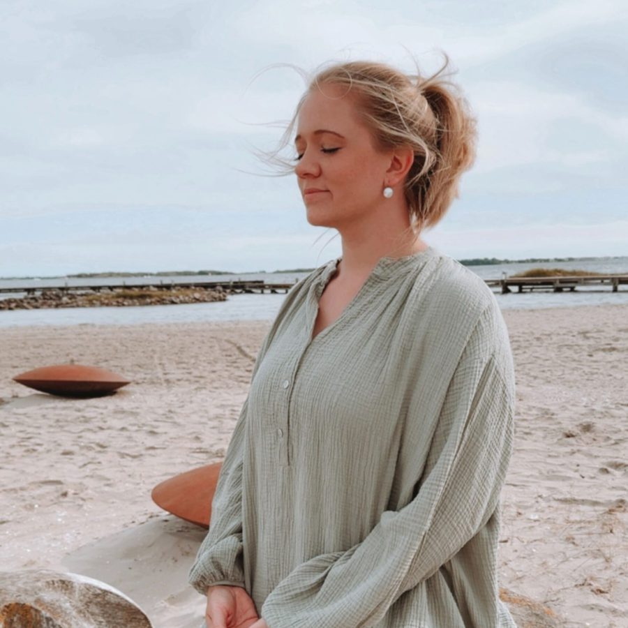 Life Coach Sophia meditiert am Strand – die innere Ruhe sorgt für inneren Frieden und für ein erfülltes Leben.