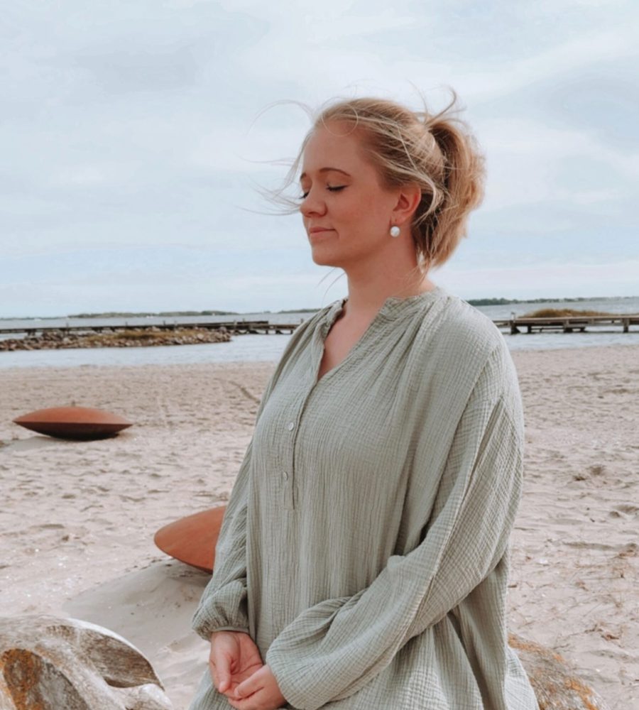 Life Coach Sophia meditiert am Strand – die innere Ruhe sorgt für inneren Frieden und für ein erfülltes Leben.